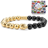 Gold and black beaded bracelet with a colorful packaging box in the background