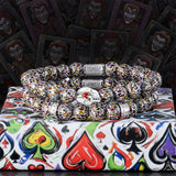 Colorful beaded bracelet on a deck of cards with joker illustrations.