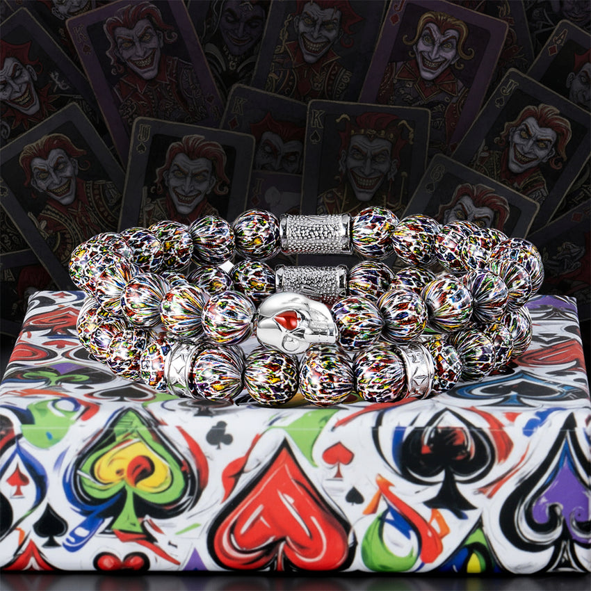 Colorful beaded bracelet on a deck of cards with joker illustrations.